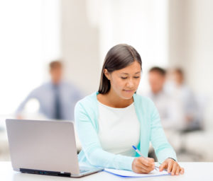 business, education and technology concept - asian businesswoman or student with laptop and documents in office